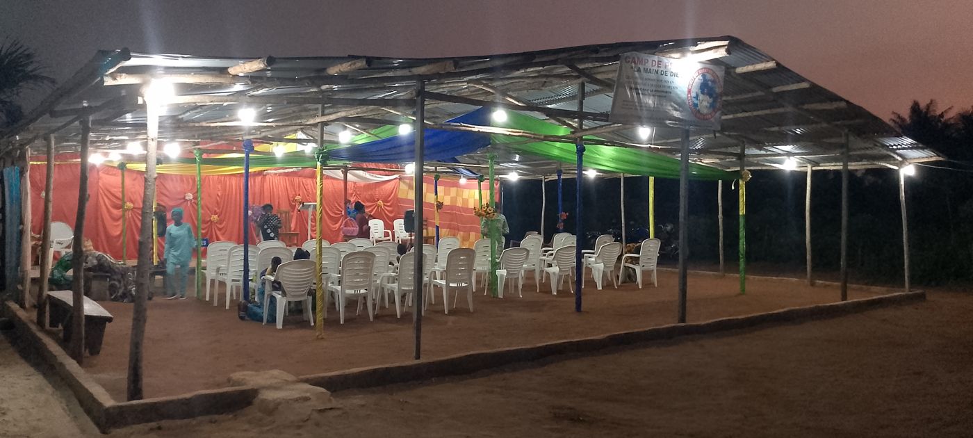 Le camp éclairé à la tombée de la nuit